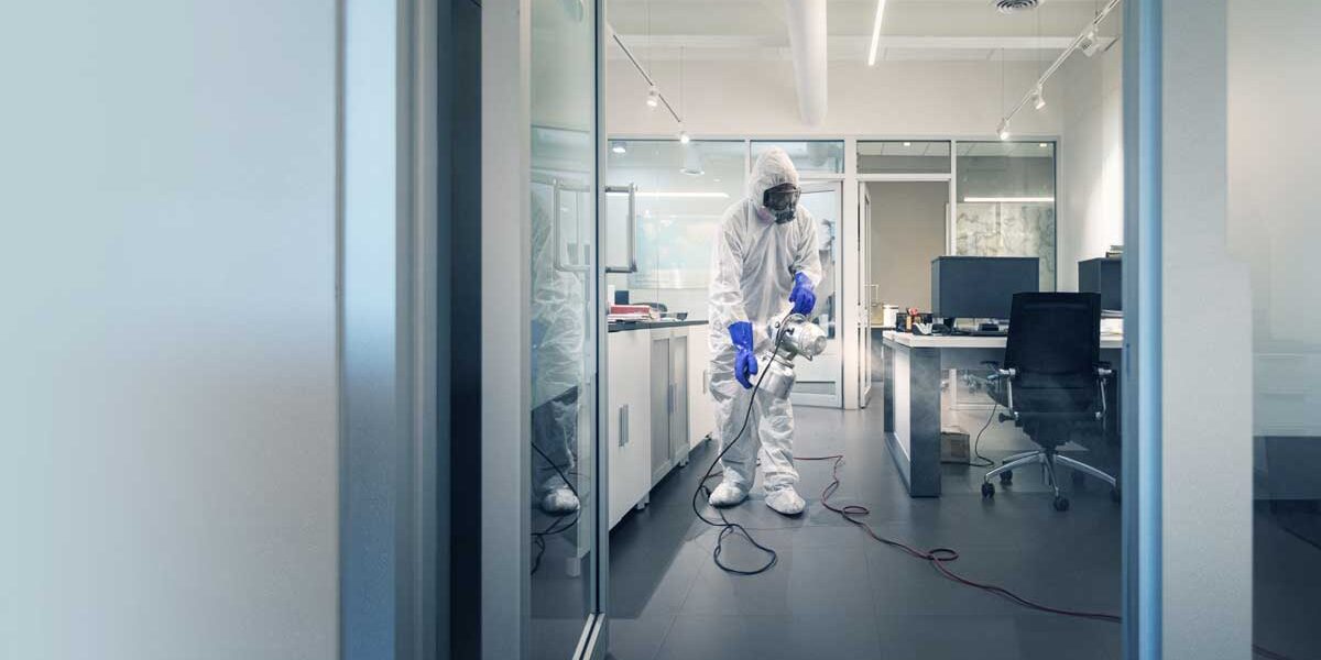 Man spraying a disinfectant inside of an office.