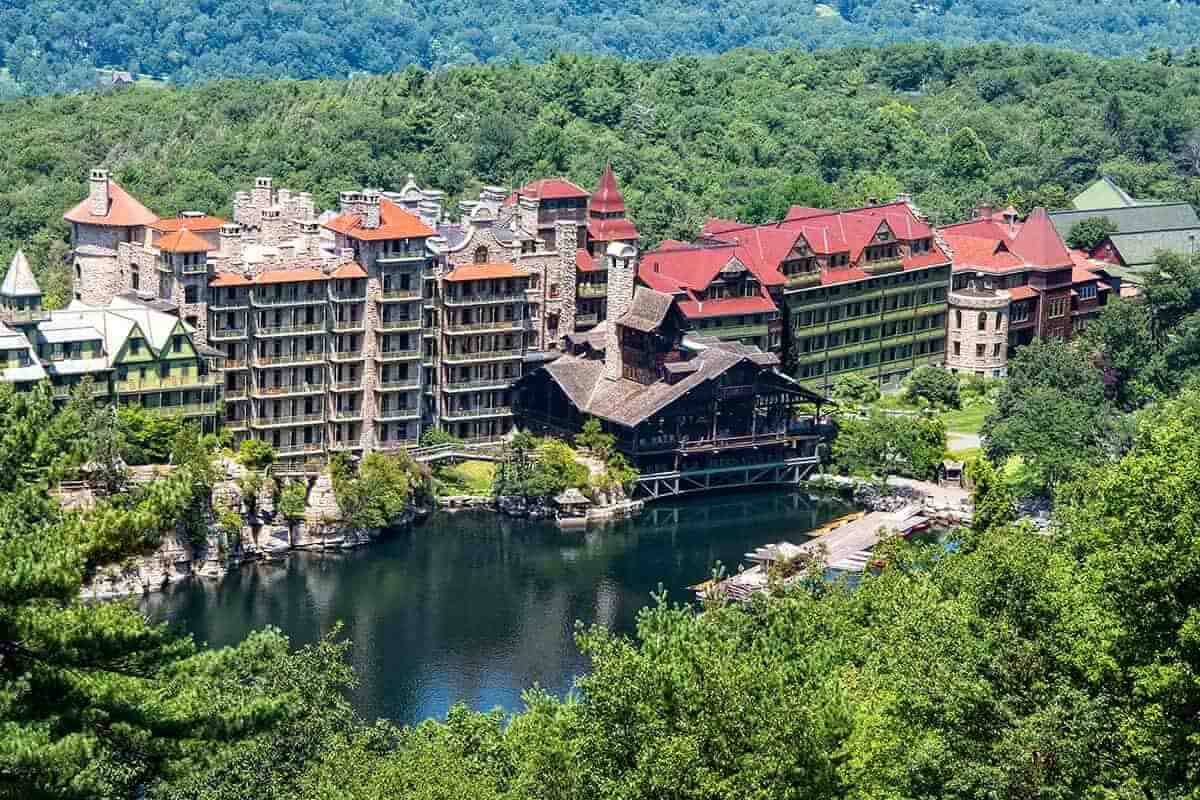 A large resort with a lake surrounded by lots of trees.
